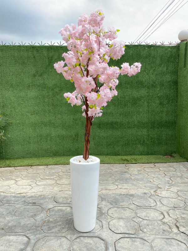 An artificial cherry blossom tree potted in a cone-shaped fiberglass vase is a breathtaking blend of elegance and modern style