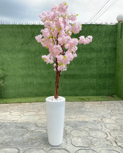 An artificial cherry blossom tree potted in a cone-shaped fiberglass vase is a breathtaking blend of elegance and modern style